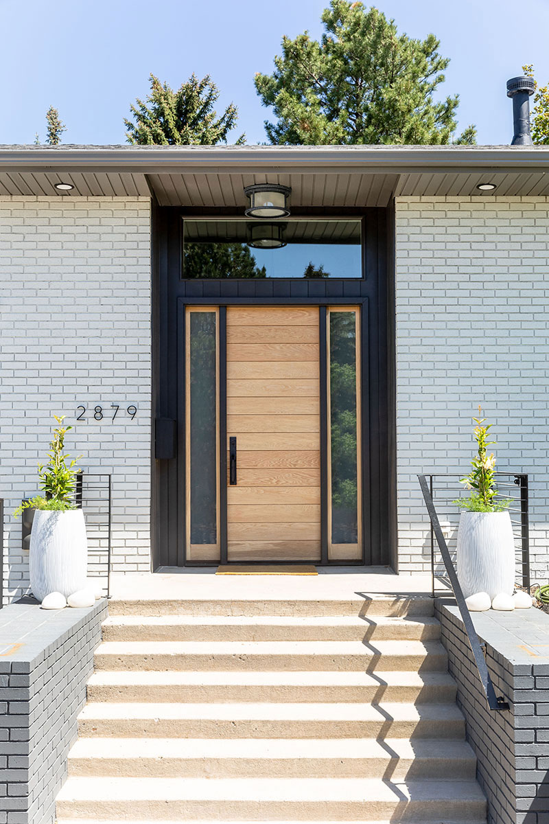 Remodeled modern brick architecture with clean horizontal lines. Contrast between brick and the wood grain of the front entryway.