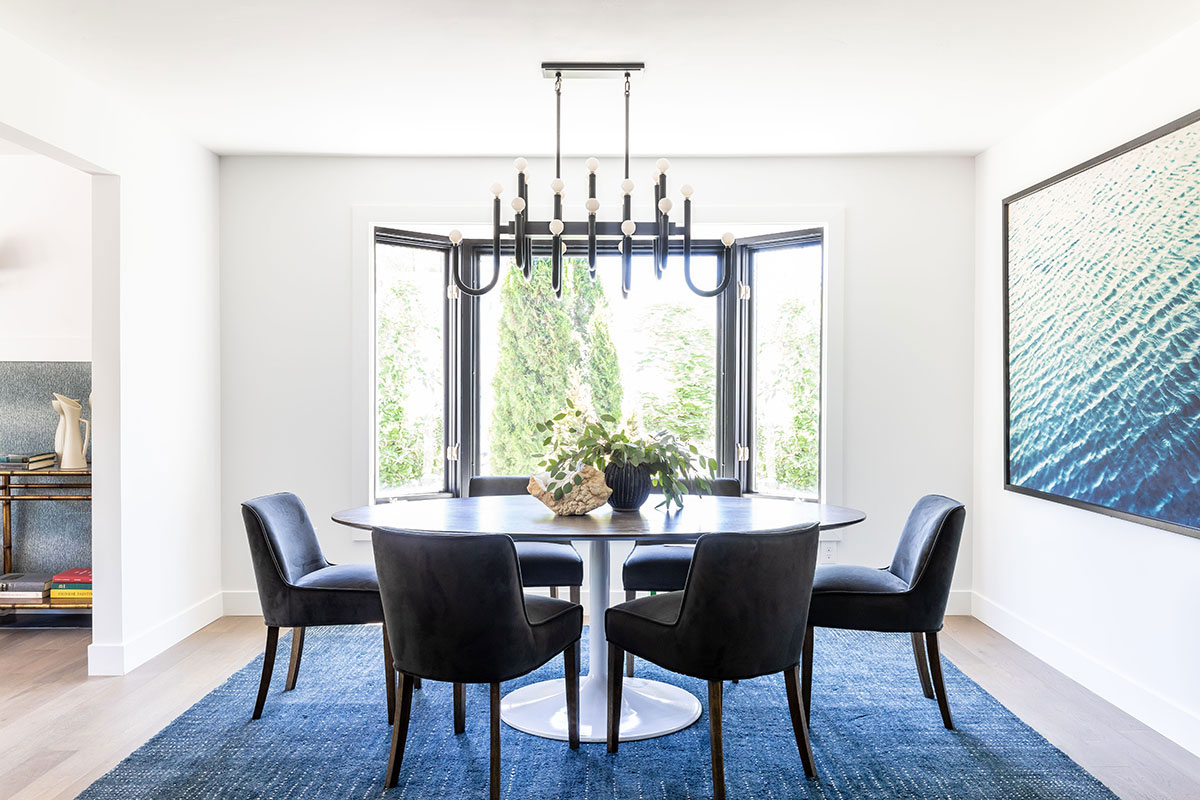 Modern dining area with blue accents and chandelier.