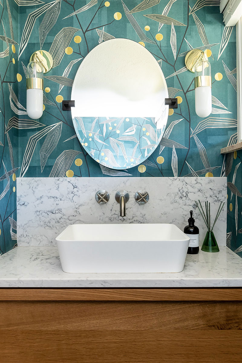 Modern bathroom redesign with colorful wallpaper and basin sink.